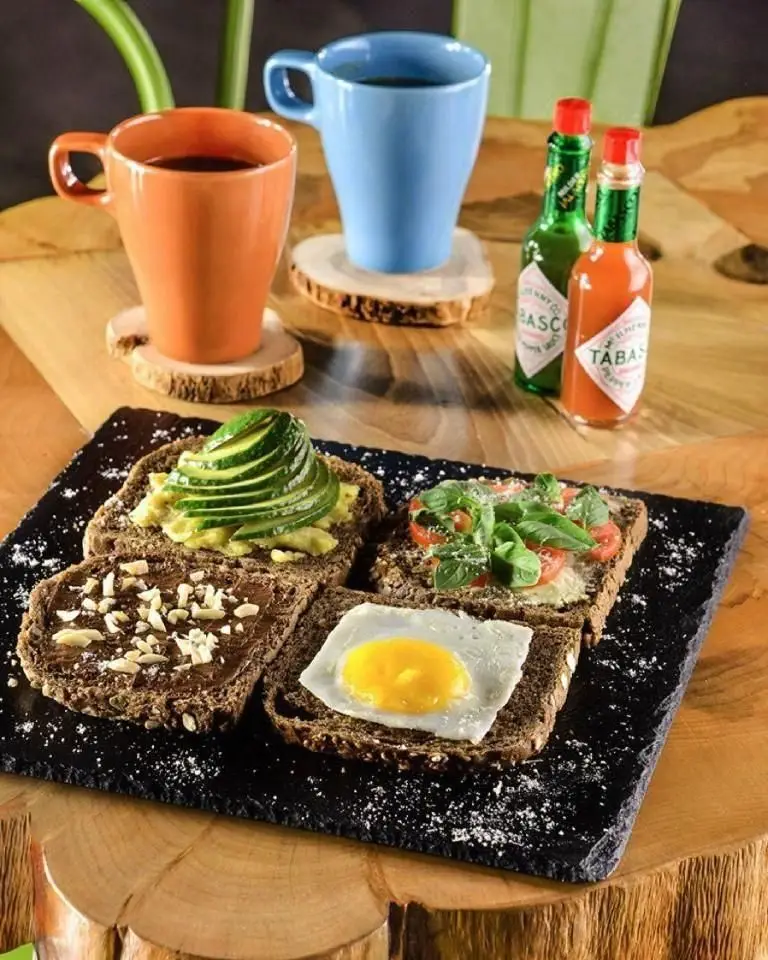 صبحانه سالم و خوشمزه کافه وصال: نان تست آووکادو، تخم مرغ، شکلات و قهوه دلنشین برای شروع روزی پر انرژی.