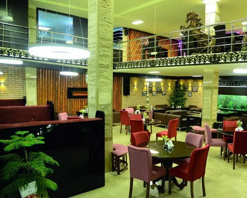 فضای داخلی کافه رستوران داریس با دکوراسیون مدرن و شیک، شامل میز و صندلی‌های راحت، مبلمان لژ و بخش طبقاتی با مجسمه اسب، مناسب برای تجربه‌ای دلنشین.