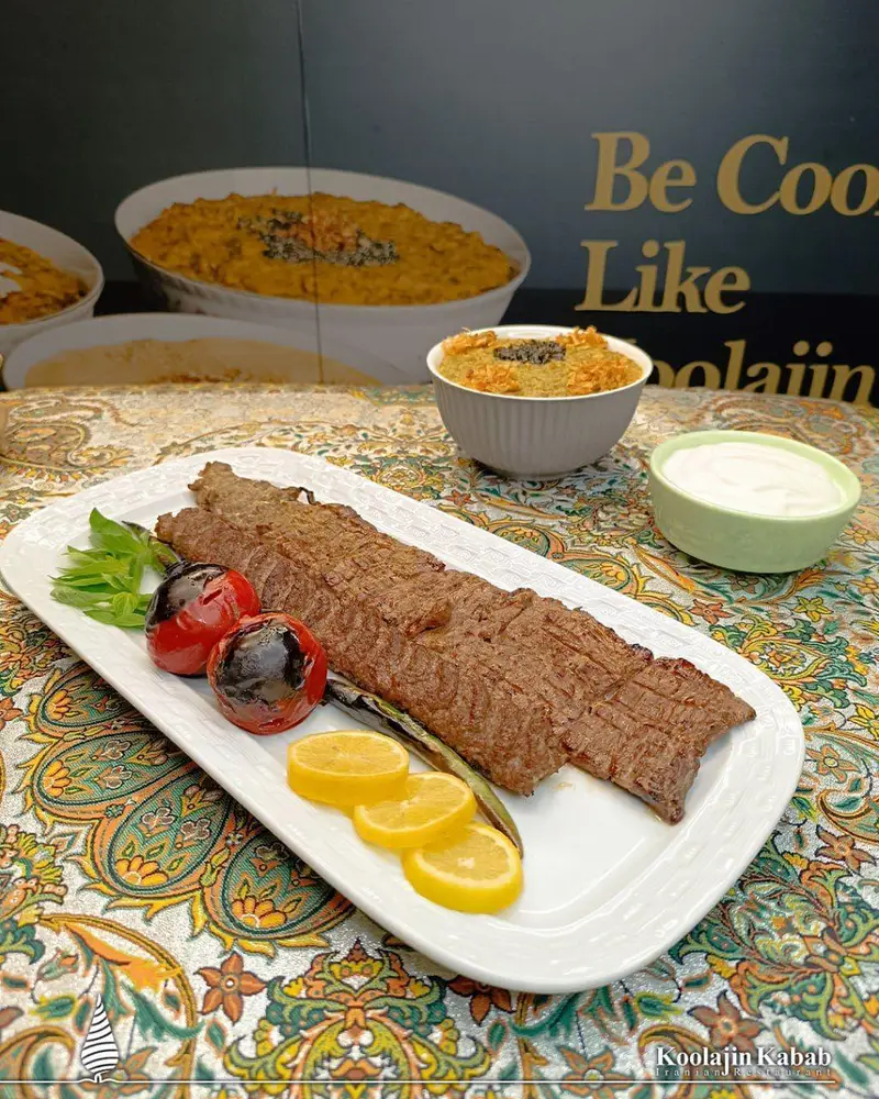 تصویری از کباب لذیذ ایرانی با مخلفات، همراه با آش و ماست در رستوران کولاژین سعادت آباد؛ بهترین غذای سنتی و اصیل.