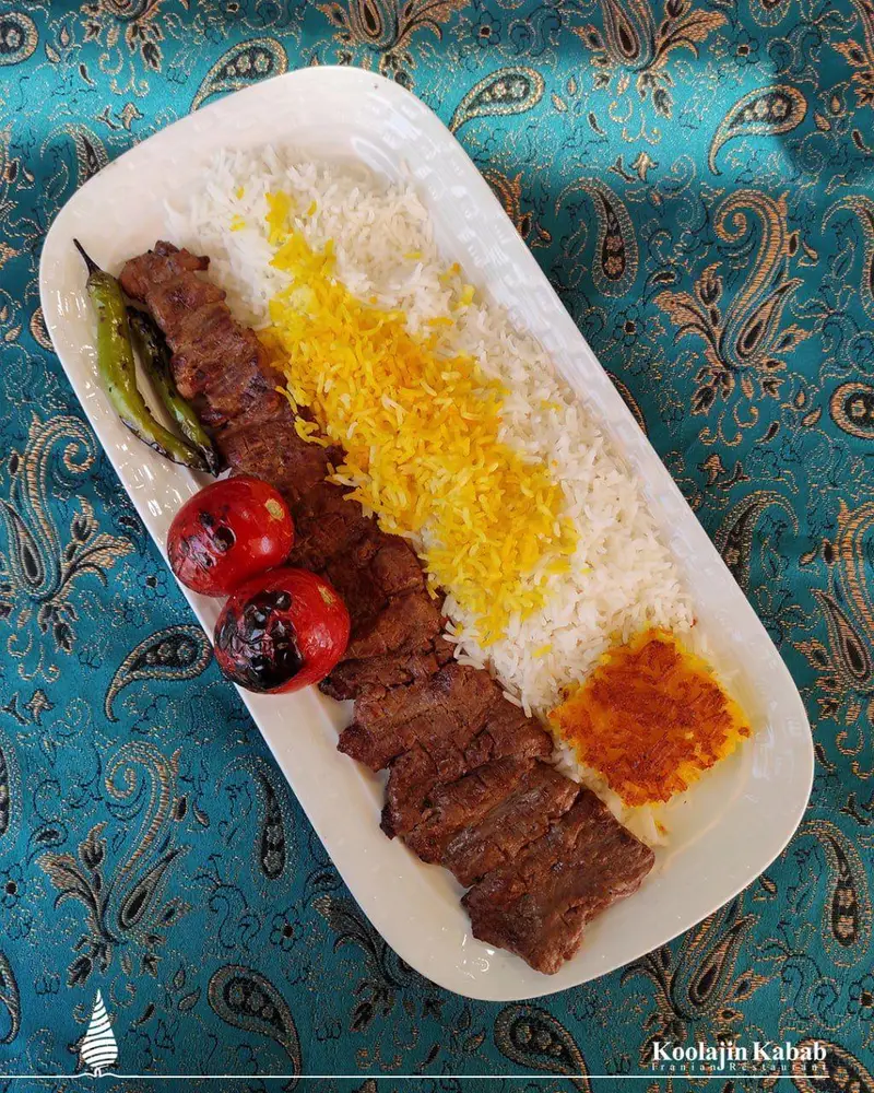 چلو کباب برگ اصیل ایرانی، سرو شده با برنج زعفرانی، گوجه و فلفل کبابی و ته دیگ، در رستوران کولاژین سعادت آباد.