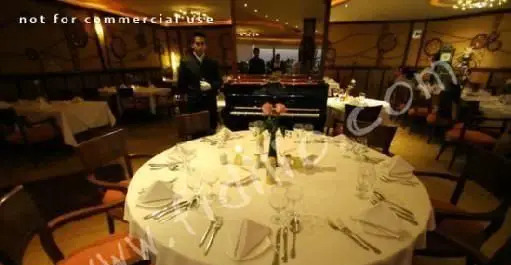 تصویری از محیط داخلی مجلل و چشم‌نواز رستوران فرنگی نارنجستان با دکوراسیون شیک، میزهای غذاخوری آماده و پیانوی زیبا، فضایی ایده‌آل برای تجربه‌ غذای بین‌المللی.