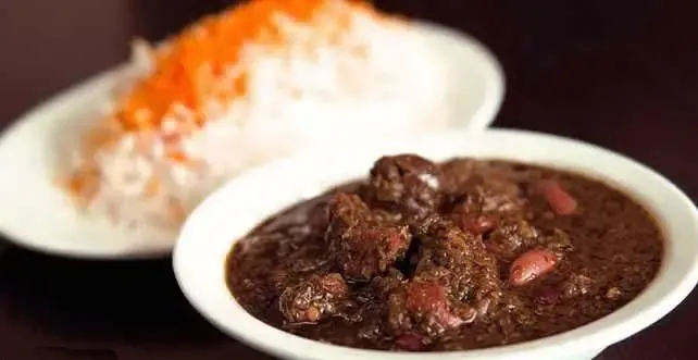 قورمه سبزی اصیل ایرانی به همراه چلو سفید زعفرانی، غذای محبوب رستوران پودات برای تجربه‌ای لذیذ از آشپزی سنتی.