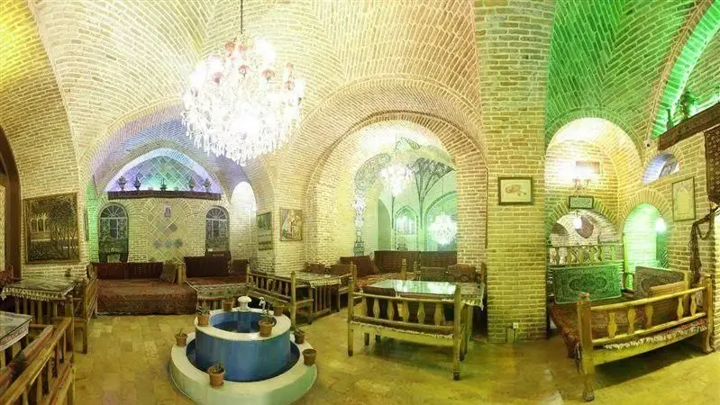 تصویری از فضای دلنشین رستوران سنتی خیام با طاق‌های آجری، حوض زیبا و تخت‌های چوبی، ایده‌آل برای صرف غذاهای اصیل ایرانی.