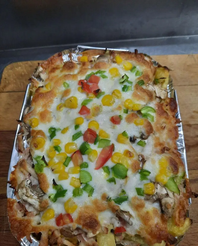 پیتزا ساندویچ آیدا: غذای فست فود پنیری و داغ با سیب زمینی، ذرت، فلفل دلمه و قارچ، طعمی بی‌نظیر برای دوستداران فست فود.