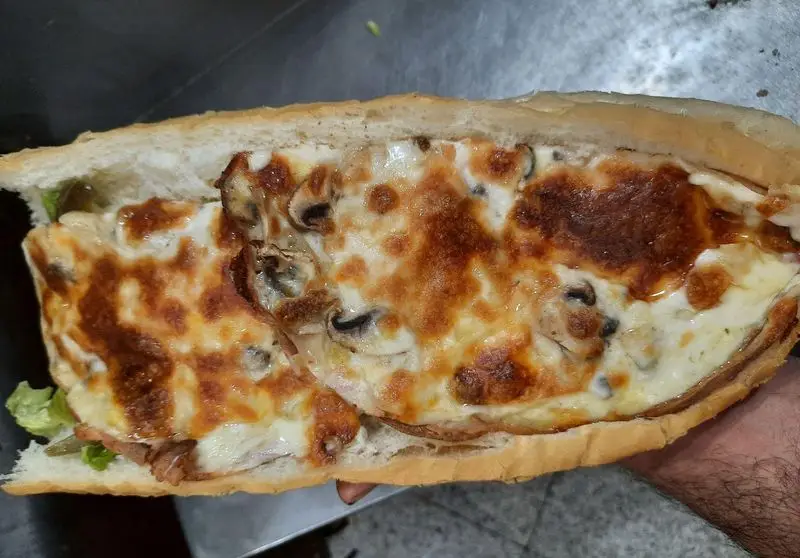 ساندویچ لذیذ و داغ قارچ و پنیر با نان تازه، پر شده با پنیر گریل شده و قارچ. محصول خاص پیتزا ساندویچ آیدا.