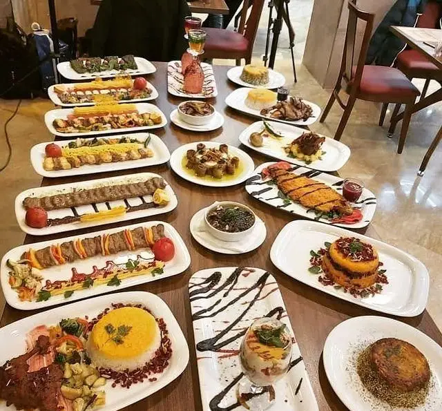 سفره‌ای مجلل از غذاهای متنوع ایرانی در رستوران رزماری شامل انواع کباب، ماهی، پلو و خوراک‌های لذیذ با دسر و نوشیدنی.