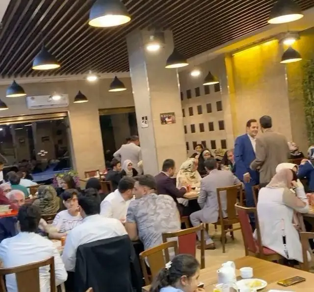 مشتریان در رستوران رزماری، در محیطی خانوادگی و دلنشین، از غذای لذیذ با نورپردازی گرم و فضایی پر جنب و جوش لذت می‌برند.