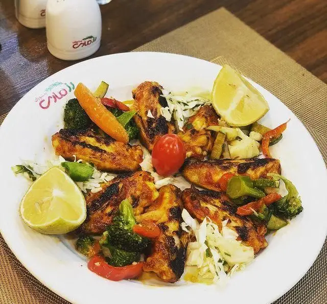 تجربه طعم بی‌نظیر رستوران رزماری: بشقاب پرطرفدار بال و کتف مرغ گریل شده همراه با سبزیجات و لیمو تازه.