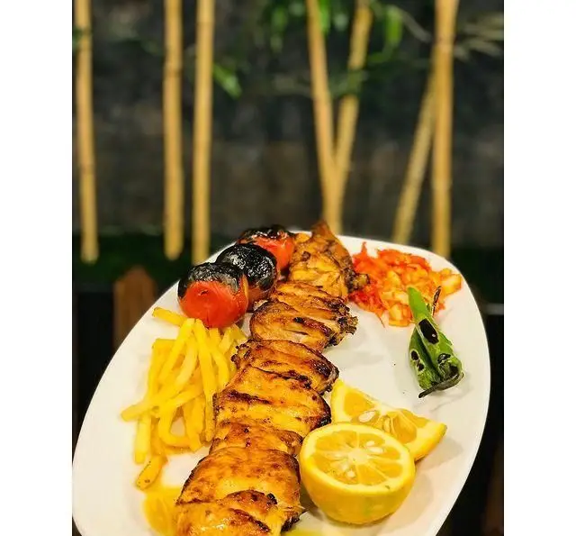 جوجه کباب لذیذ با سیب‌زمینی، گوجه و فلفل کبابی، غذای اصلی محبوب در رستوران رزماری. تجربه‌ای بی‌نظیر از غذای ایرانی.