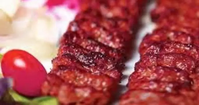 تصویری از سیخ‌های کباب آبدار و لذیذ تهیه غذا پارسی، با تزئین گوجه و مخلفات تازه. غذای اصیل و باکیفیت ایرانی.