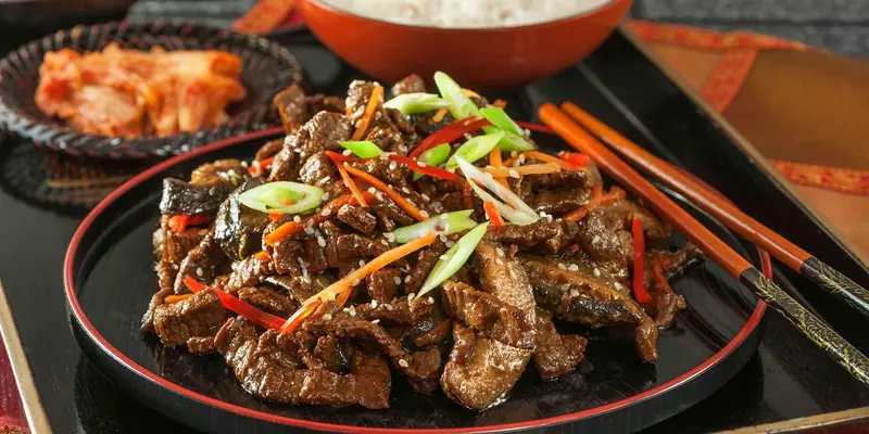 سرو بیف بولگوگی لذیذ و کیمچی سنتی در رستوران آسیایی توکیو، تجربه‌ای بی‌نظیر از طعم‌های اصیل و دلپذیر غذای آسیایی.