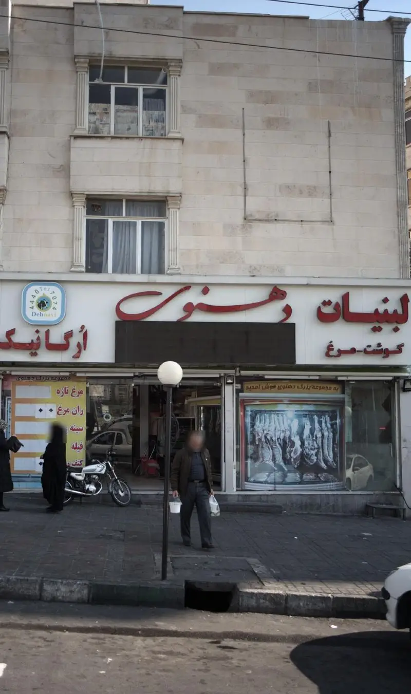 نمایی از فروشگاه لبنیات دهنوی، عرضه کننده لبنیات ارگانیک و گوشت مرغ تازه، در یک روز آفتابی با حضور مشتریان.