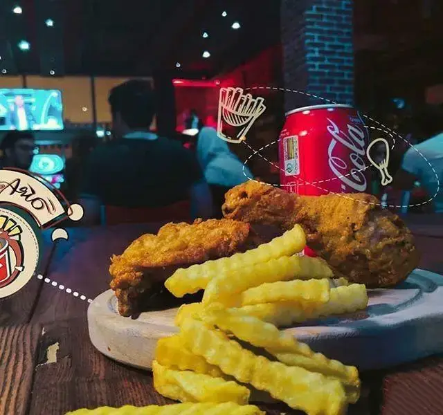 نمایی از مرغ سوخاری ترد، سیب‌زمینی سرخ‌کرده طلایی و نوشابه کوکاکولا در محیط جذاب فست فود آریو. طعم بی‌نظیر و کیفیت عالی!