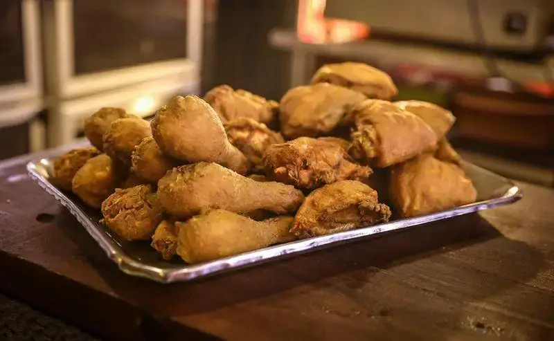 سینی بزرگ از مرغ سوخاری طلایی و ترد فست فود آریو، آماده سرو، بهترین گزینه برای یک وعده غذایی لذیذ و پرطرفدار.