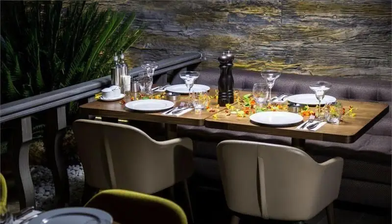 تصویر فضای دلنشین و دنج رستوران کاساب در شب، با میزهای شام شیک و چیدمان کامل برای تجربه‌ای خاص و به‌یادماندنی.