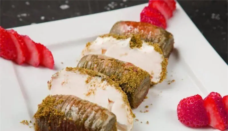 دسر خوشمزه و خاص رستوران کاساب: رول‌های شیرین با مغز خامه یا بستنی و پودر پسته فراوان، سرو شده با توت فرنگی تازه، انتخابی ایده‌آل