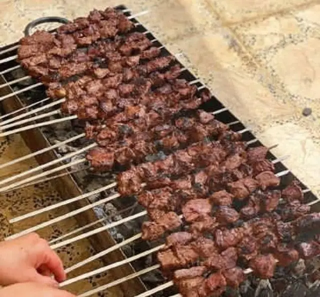 کباب‌های جگر و گوشت تازه و آبدار جگرسرای وحید در حال پخت روی گریل ذغالی. طعم اصیل و لذیذ برای عاشقان کباب جگر.