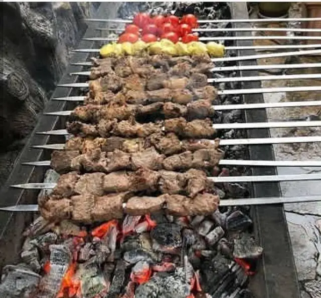 کباب گوشت لذیذ و تازه، همراه با گوجه و سیب‌زمینی روی ذغال داغ در جگرسرای وحید. تجربه‌ای بی‌نظیر از غذای سنتی.