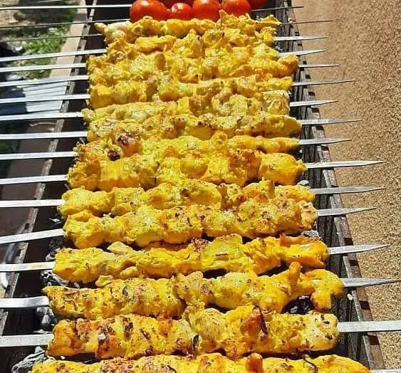 سیخ‌های جوجه کباب زعفرانی تازه و خوشرنگ جگرسرای وحید در حال آماده شدن برای پخت. تجربه طعم بی‌نظیر در جگرسرا وحید.