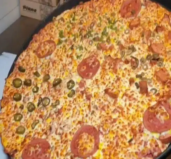 پیتزا متنوع و بزرگ فست فود زنجیره ای پیانو با پپرونی، زیتون، فلفل هالوپینو و سوسیس فراوان، غرق در پنیر کش‌دار و لذیذ.