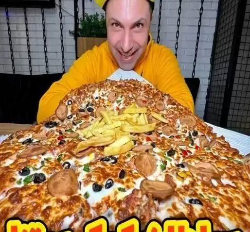 تجربه خوردن پیتزای عظیم و پر از مخلفات با سیب زمینی سرخ کرده توسط مشتری هیجان زده در فست فود زنجیره ای پیانو.