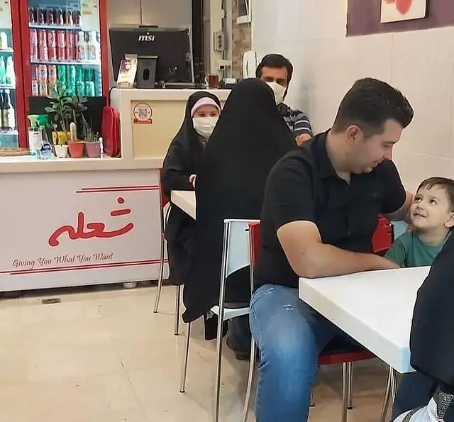 تصویری دلنشین از خانواده‌ای در حال لذت بردن از وعده غذایی در فست فود شعله، از شعب محبوب زنجیره فست فود پیانو.